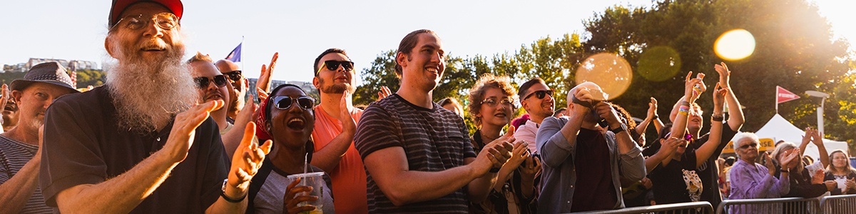 a crowd of people smiling and clapping