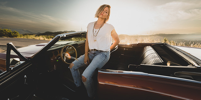 KT Tunstall sitting in the driver's seat of a vintage convertible car